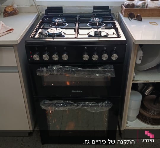 תנור משולב כיריים גז שחור של בלומברג המחובר ודולק במטבח
